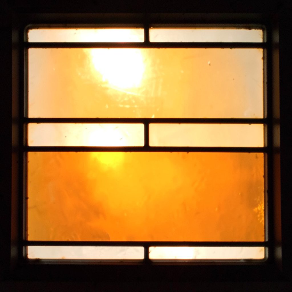 Stained-glass panel in warm amber and white, simple rectangular divisions