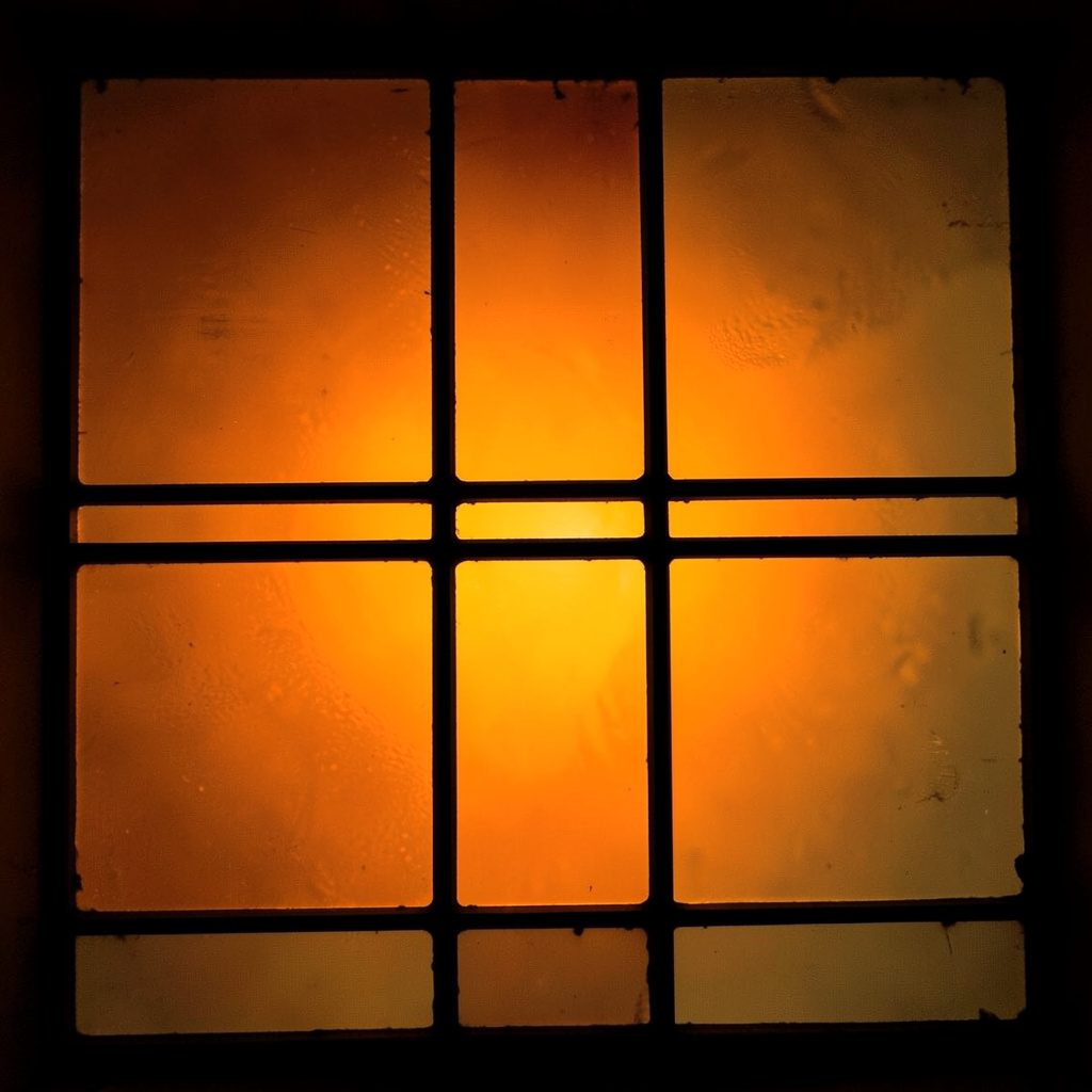 Stained-glass fragment in charcoal and ochre, large rectangular panels
