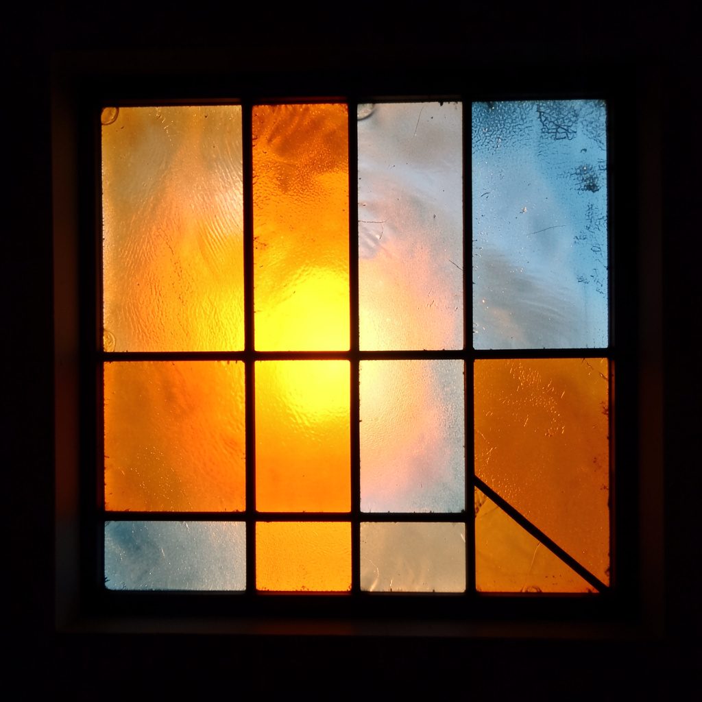 Stained-glass square in warm orange and muted blue, fine lead lines