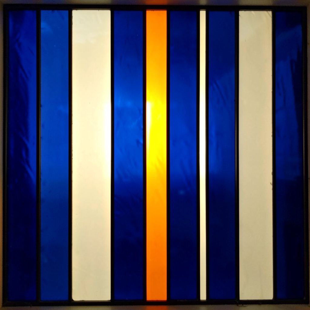 Stained-glass panel in deep blue and ivory, narrow vertical divisions