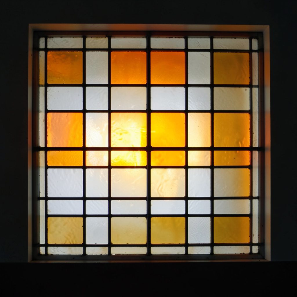 Stained-glass square in pale grey and ochre, regular grid