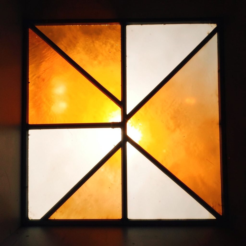 Stained-glass square in warm amber and soft white, asymmetric divisions